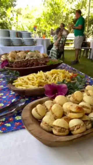 Buffet servido ao ar livre com pães, salgados e porções